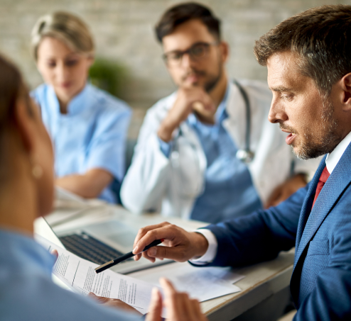 Mid Adult Businessman Healthcare Workers Analyzing Documents Meeting Office